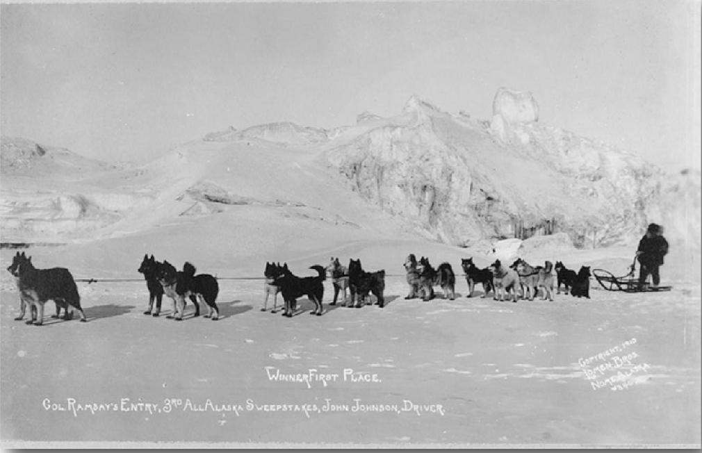 Alaszka,1910. John Jonson husky kutyáival  szánhúzásközben(en.wikipedia.org)